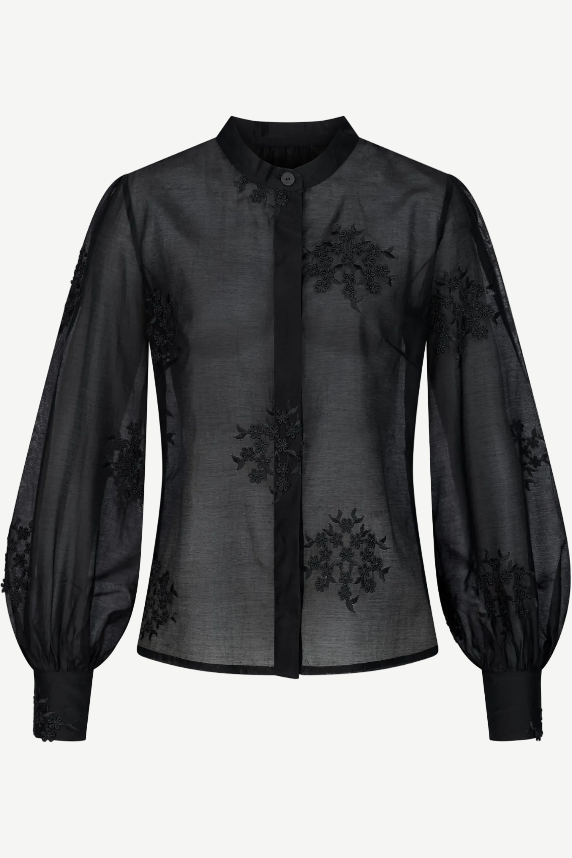 Detailansicht der schwarzen Bluse mit erhabener floraler Stickerei auf transparentem Viskosestoff.