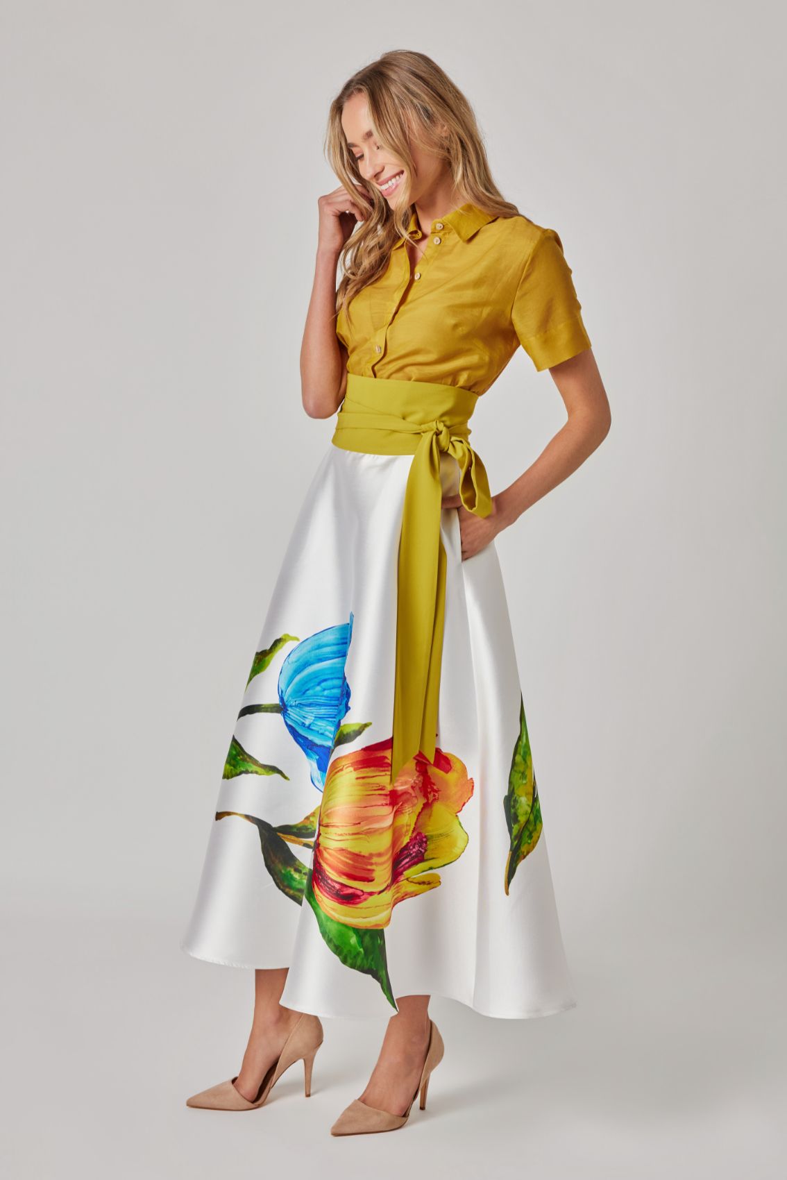 Model trägt Midirock mit Tulpenprint, Seitenansicht, ausgestellte Silhouette, satinig-glatter Fall.