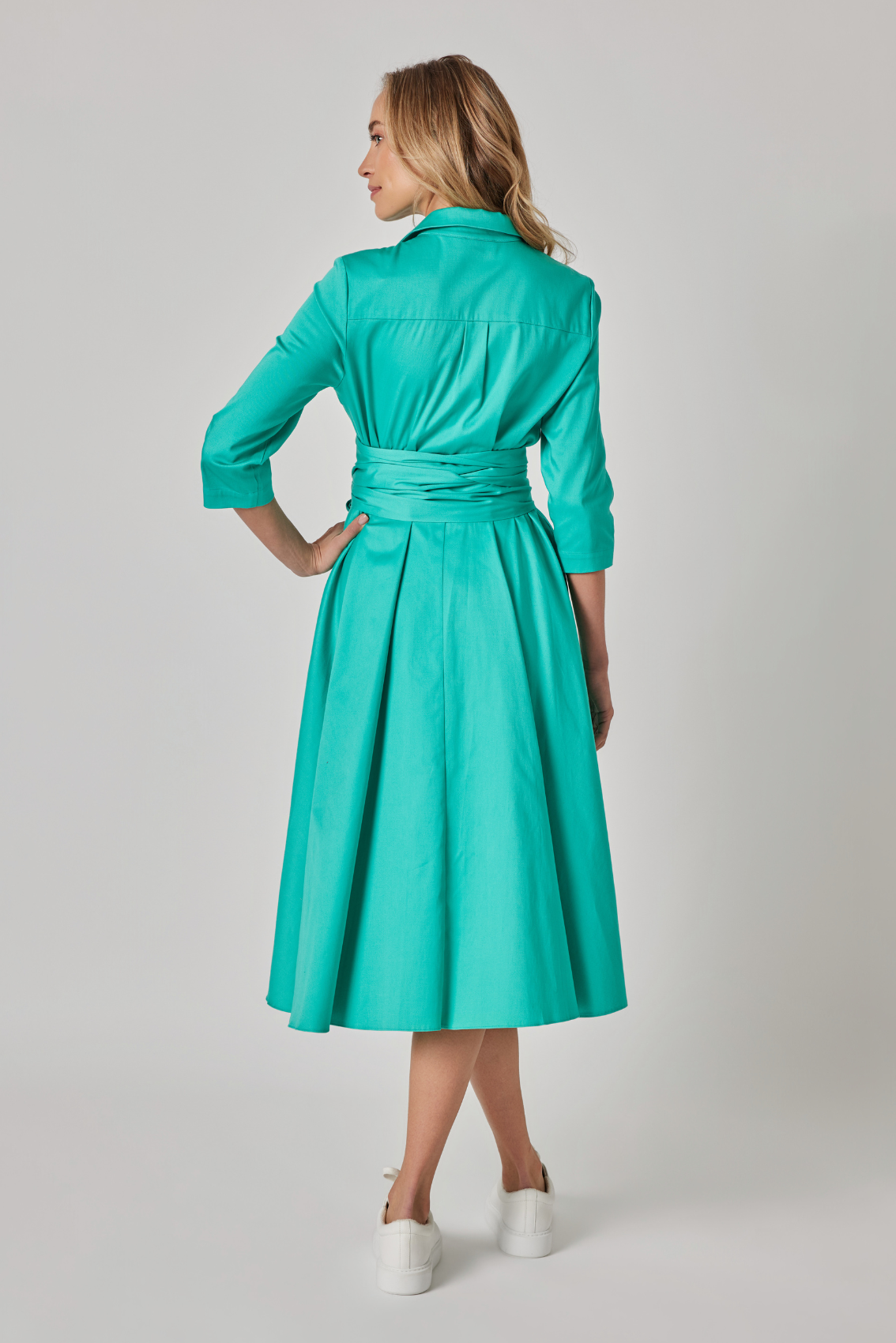 Model trägt türkises Hemdblusenkleid mit taillierter Silhouette, Rückenansicht.