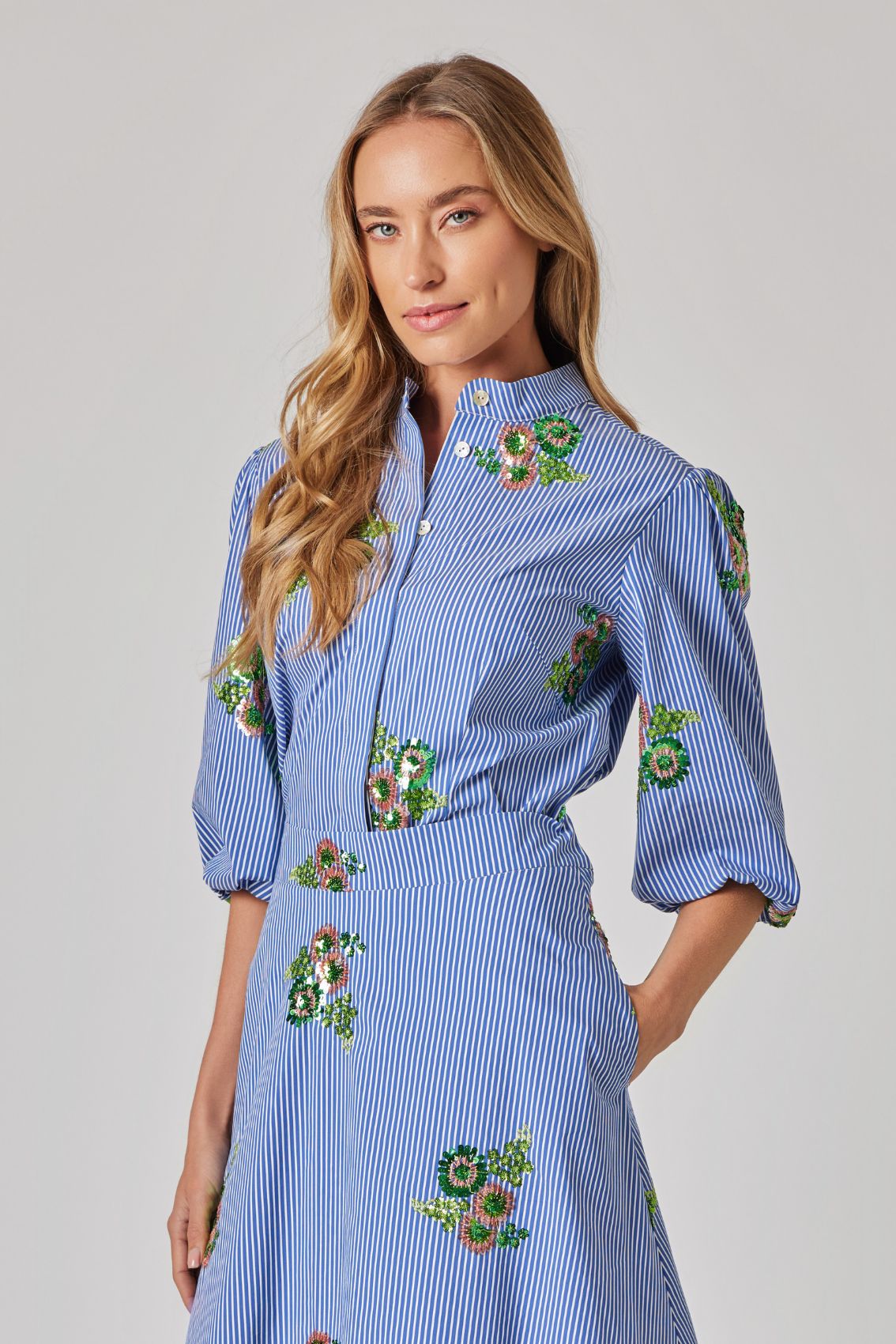 Model trägt die Bluse mit Paillettenblüten, 3/4-Ärmel mit Volumen, Seitenansicht.