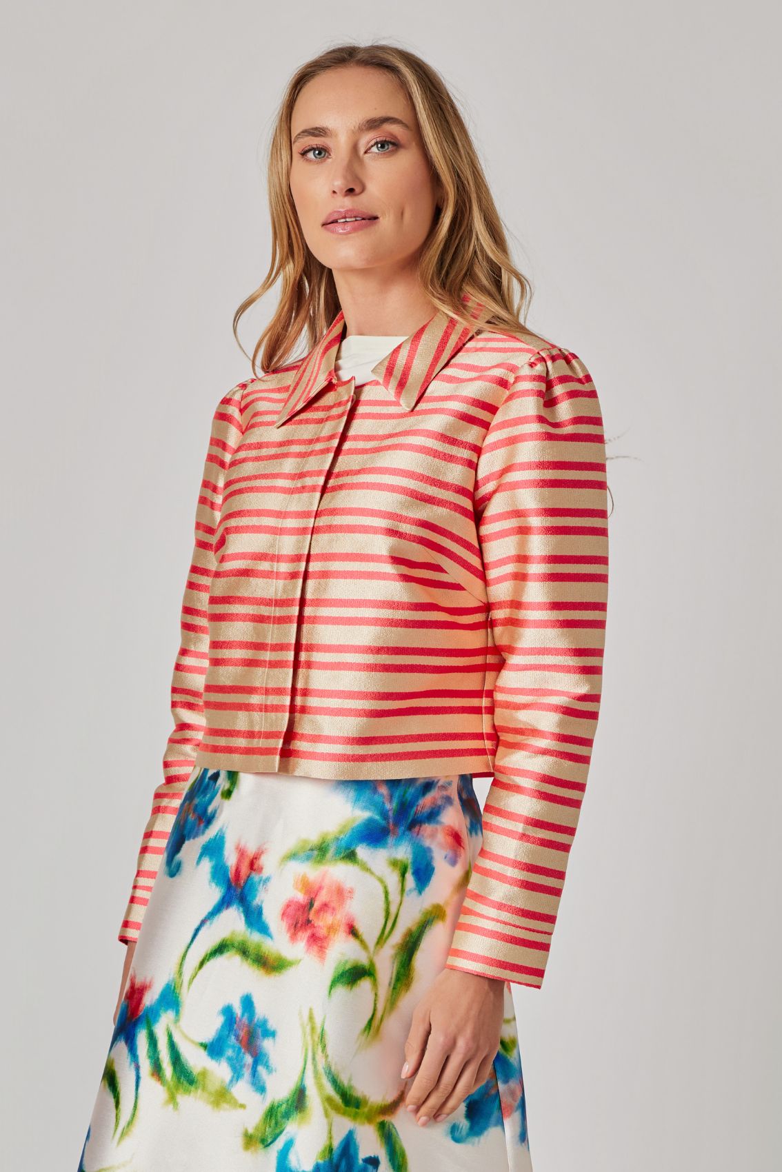 Model trägt gold-orange gestreifte Kurzjacke geschlossen, cleanes Frontbild.