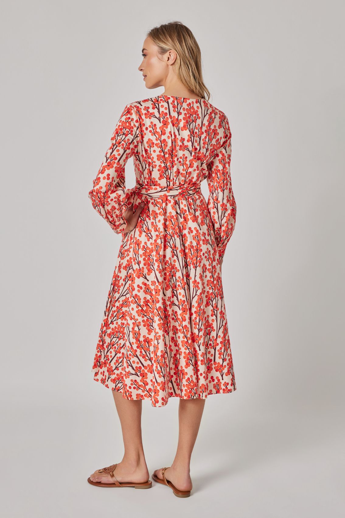 Model trägt Wickelkleid Sanddorn, Rückansicht mit Allover-Print und locker fallenden langen Ärmeln.