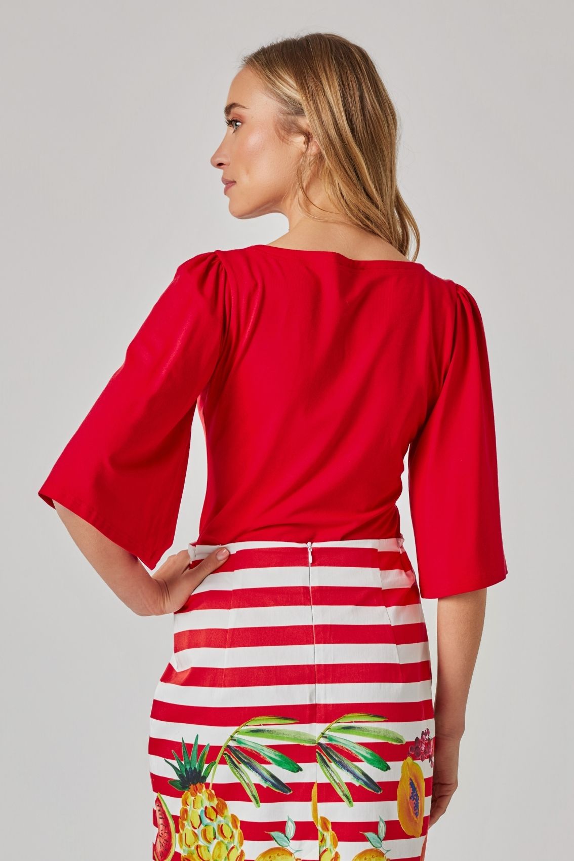 Model trägt rotes Shirt mit Herz-Ausschnitt und weiten Ärmeln, Rückenansicht