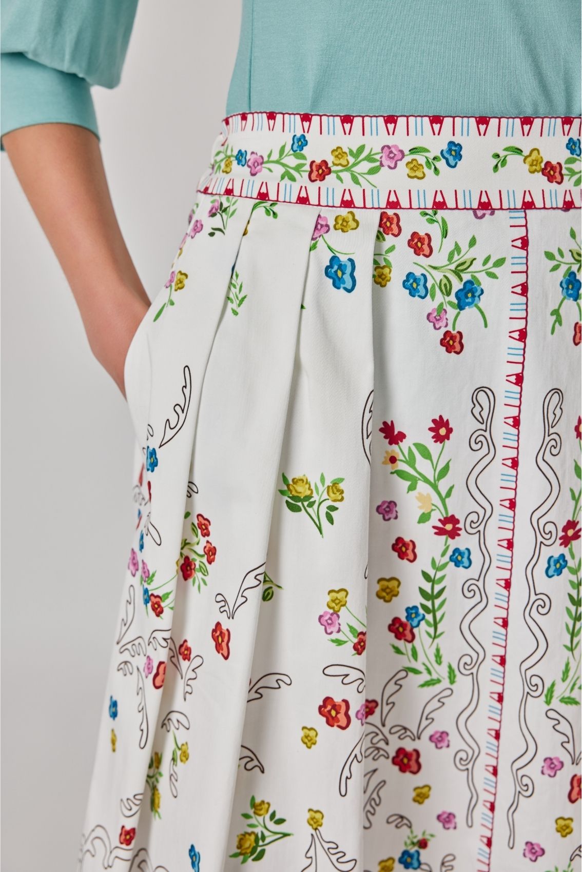 Detailansicht des Midirocks mit Blumenprint mit dekorativem Bund und floralem Bordürenmuster.
