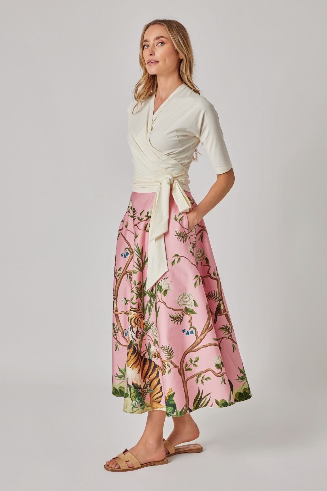 Model trägt Maxirock mit Tiger-Print in Rosa, Seitenansicht, fließende Bewegung und klare Linienführung der Silhouette