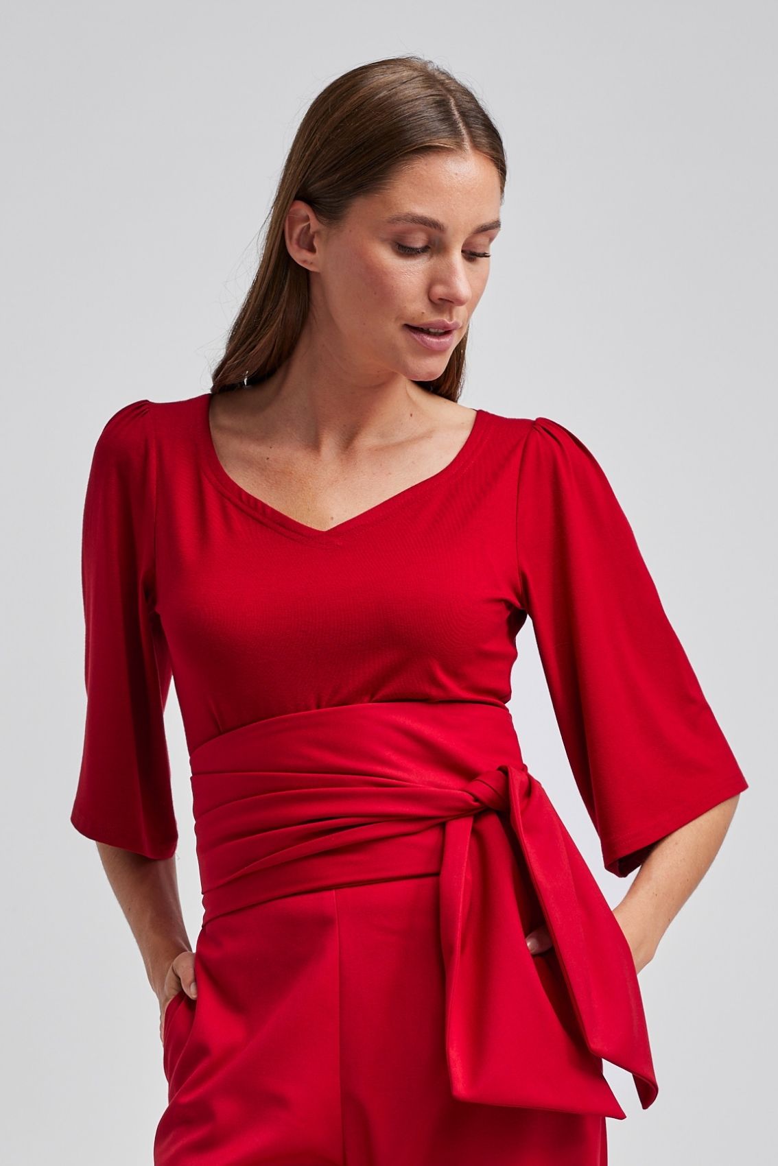 Model trägt rotes Shirt mit Herz-Ausschnitt und sehr lockeren 3/4-Ärmeln, Frontalansicht.