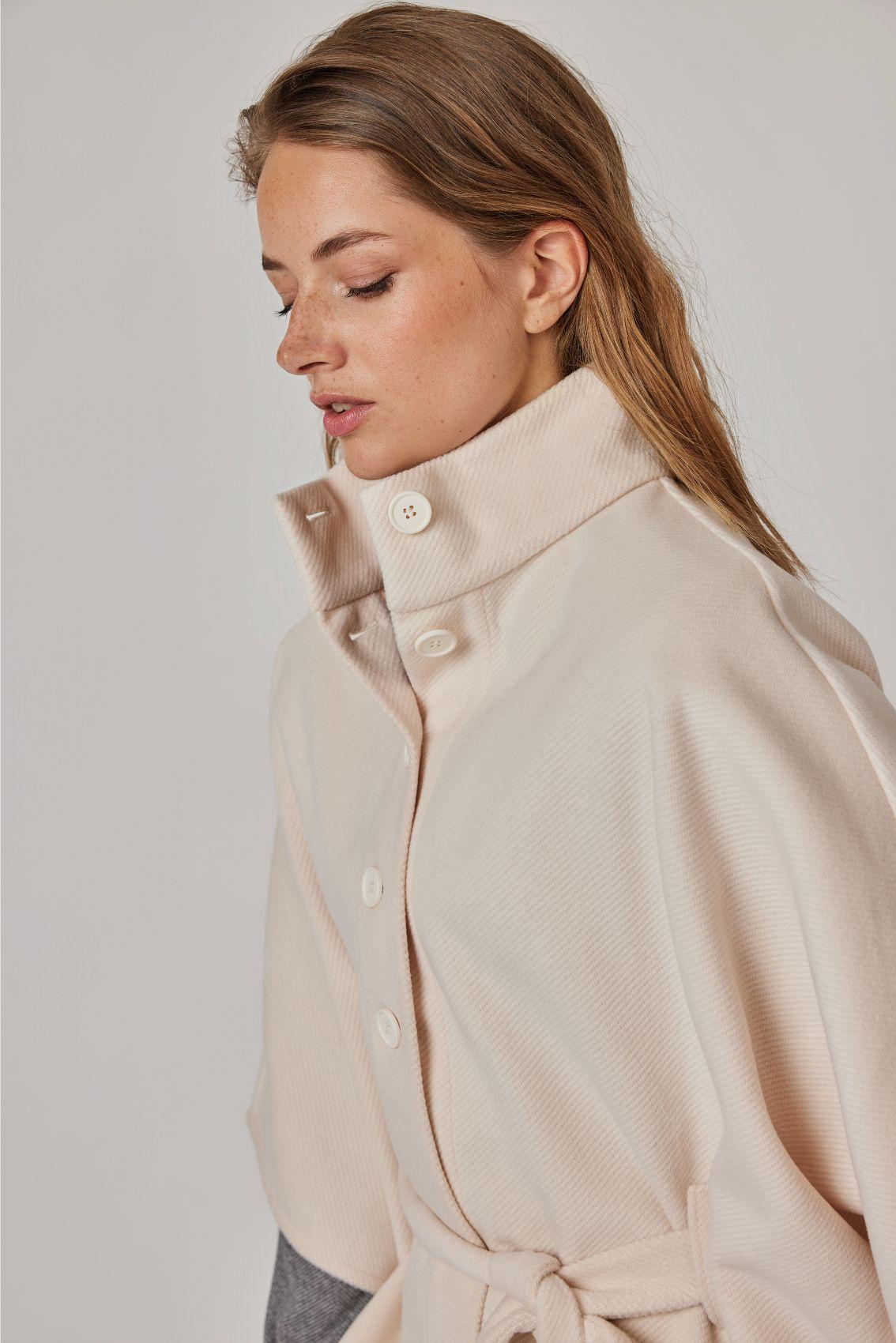 Cape Creme: Detailansicht Stehkragen mit Knopfleiste, seitliche Perspektive.