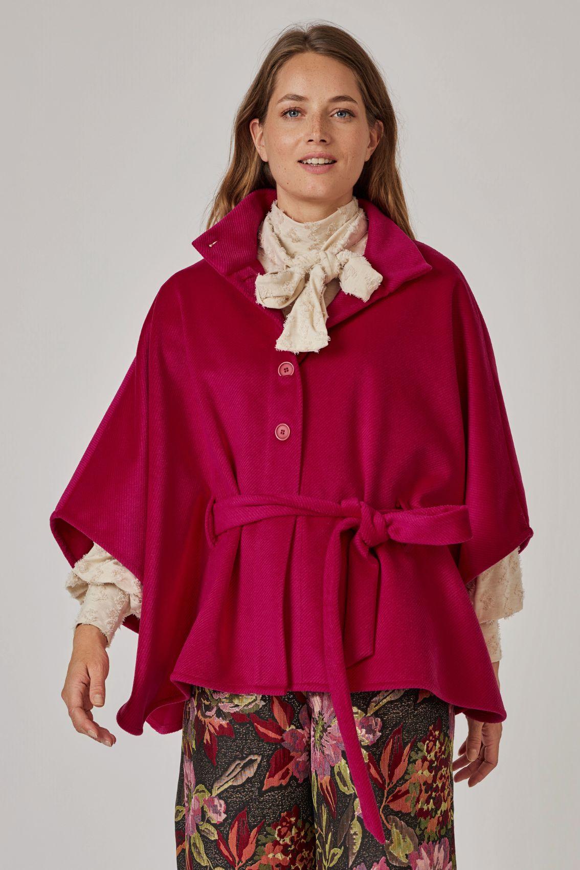 Model trägt Cape Magenta mit Stehkragen und geschlossenem Bindegürtel, Frontansicht.