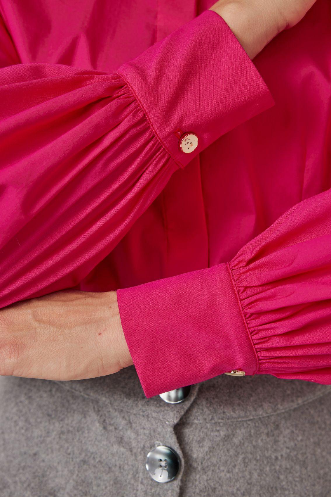 Detailansicht: geraffte Manschette mit Emailleknopf in Magenta.
