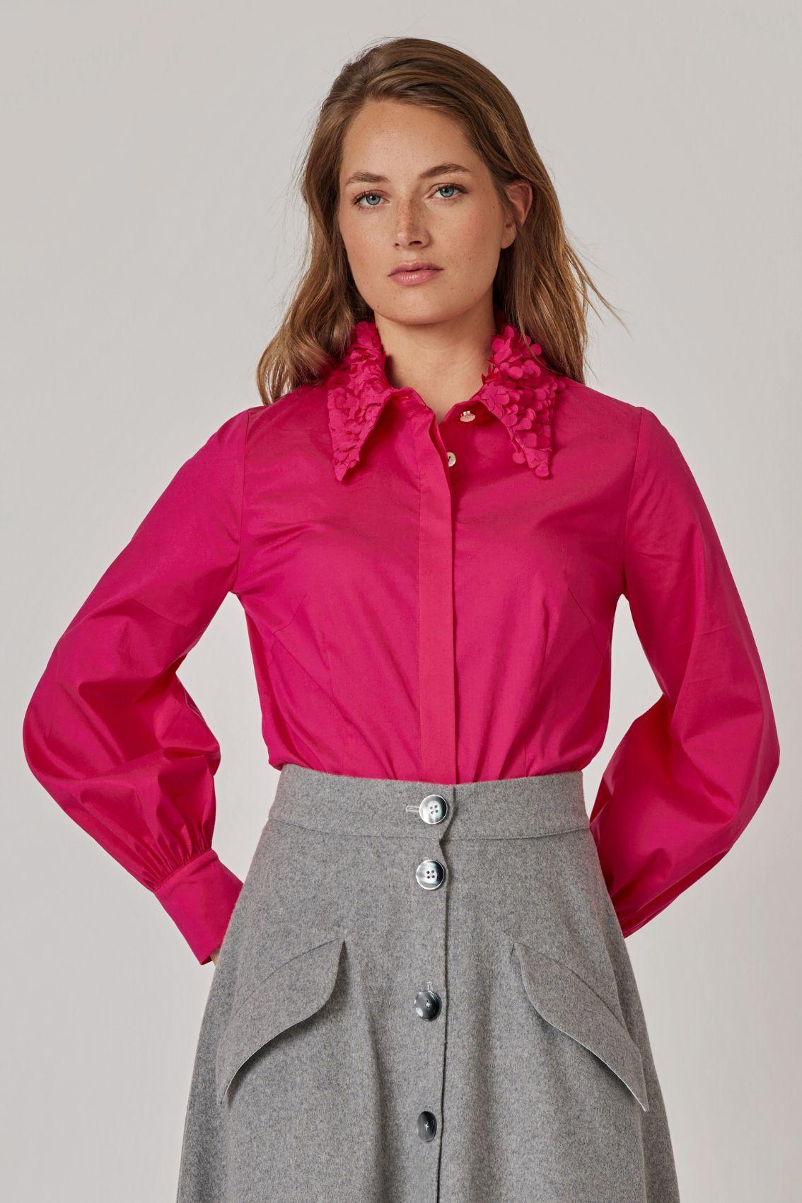 Model trägt magentafarbene Bluse mit floralem Kragen, Frontansicht