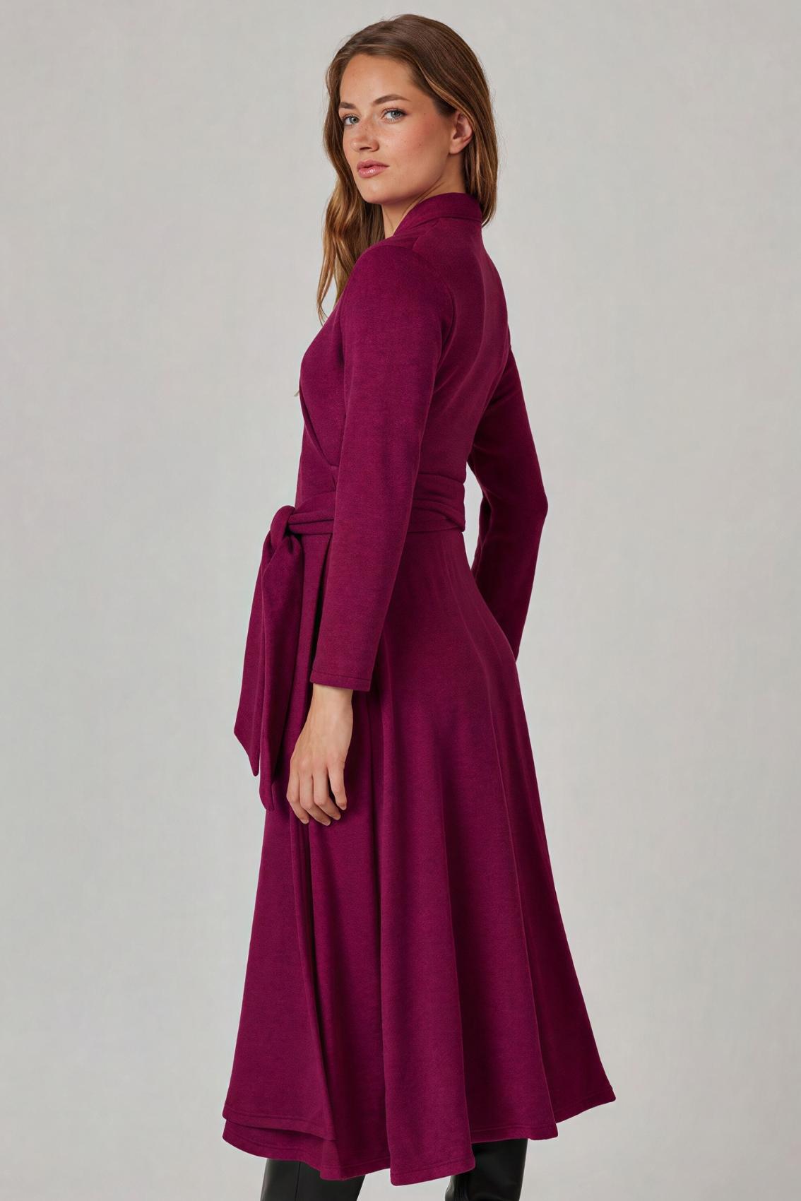Model trägt beerefarbenes Wickelkleid, Seitenansicht mit geschlossenem Bindegürtel und fließendem Rock.