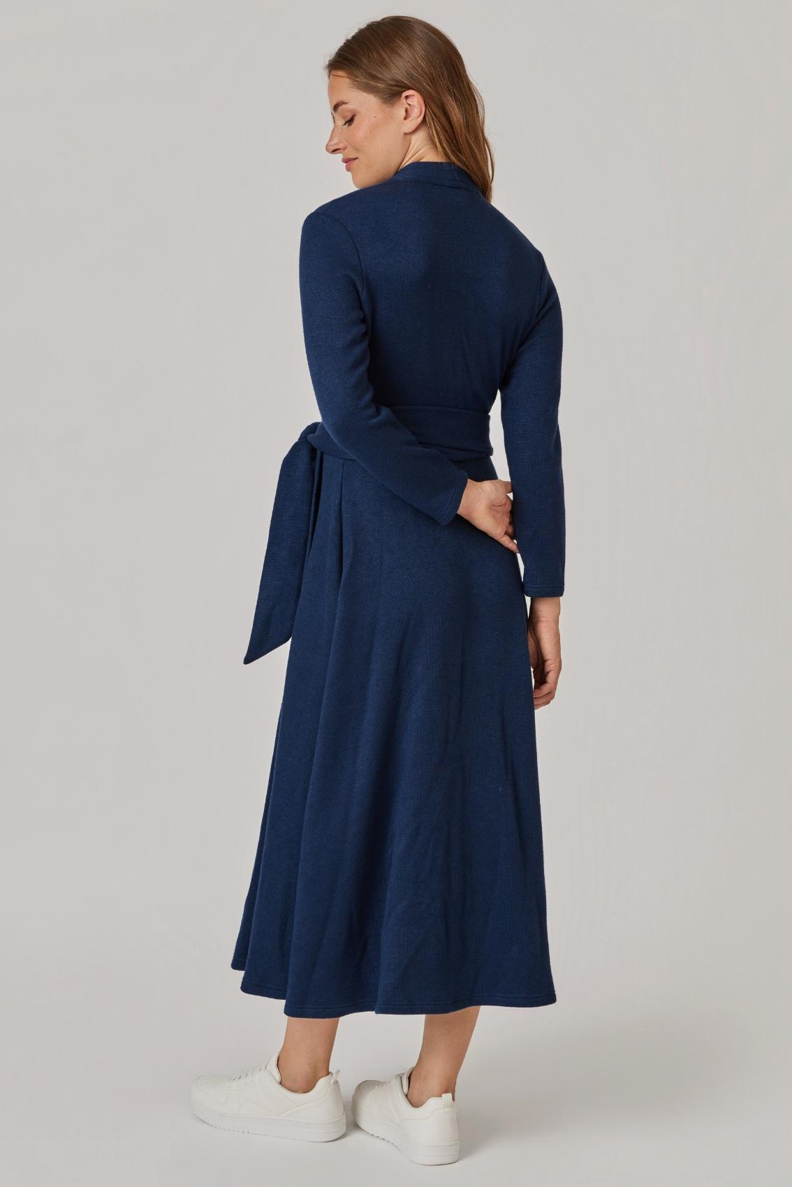 Model trägt navyfarbenes Wickelkleid, Rückenansicht mit zur Schleife gebundenem Bindegürtel.