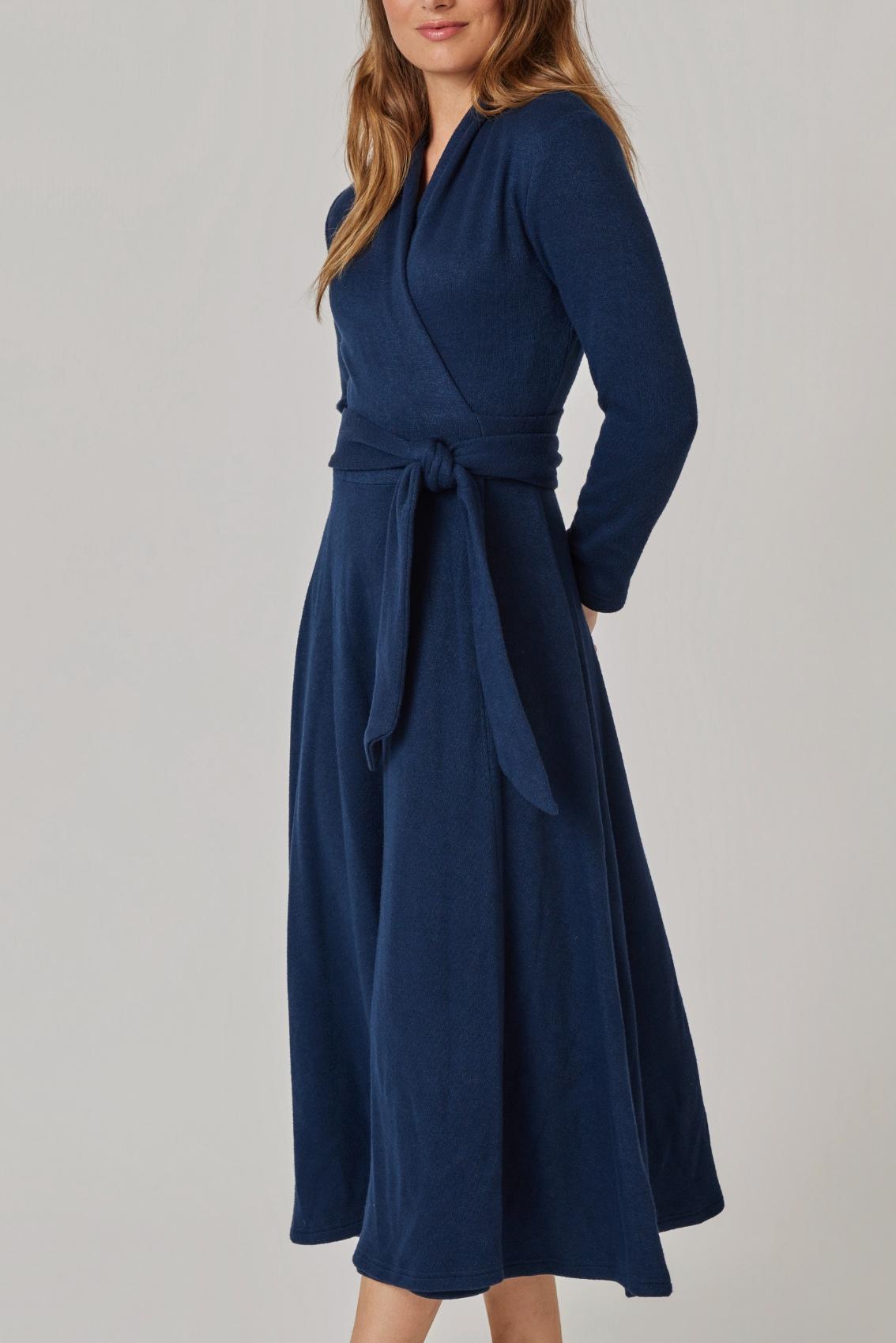Model trägt navyfarbenes Wickelkleid, Seitenansicht mit geschlossenem Bindegürtel und fließendem Rock.