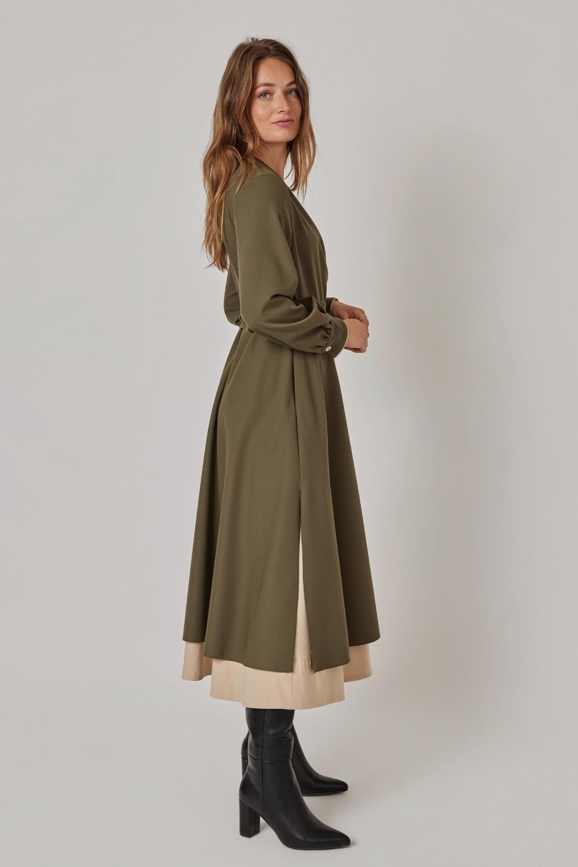 Model trägt Wickelkleid Olive-Sand, Seitenansicht mit seitlichem Schlitz und sichtbarem Unterrock.