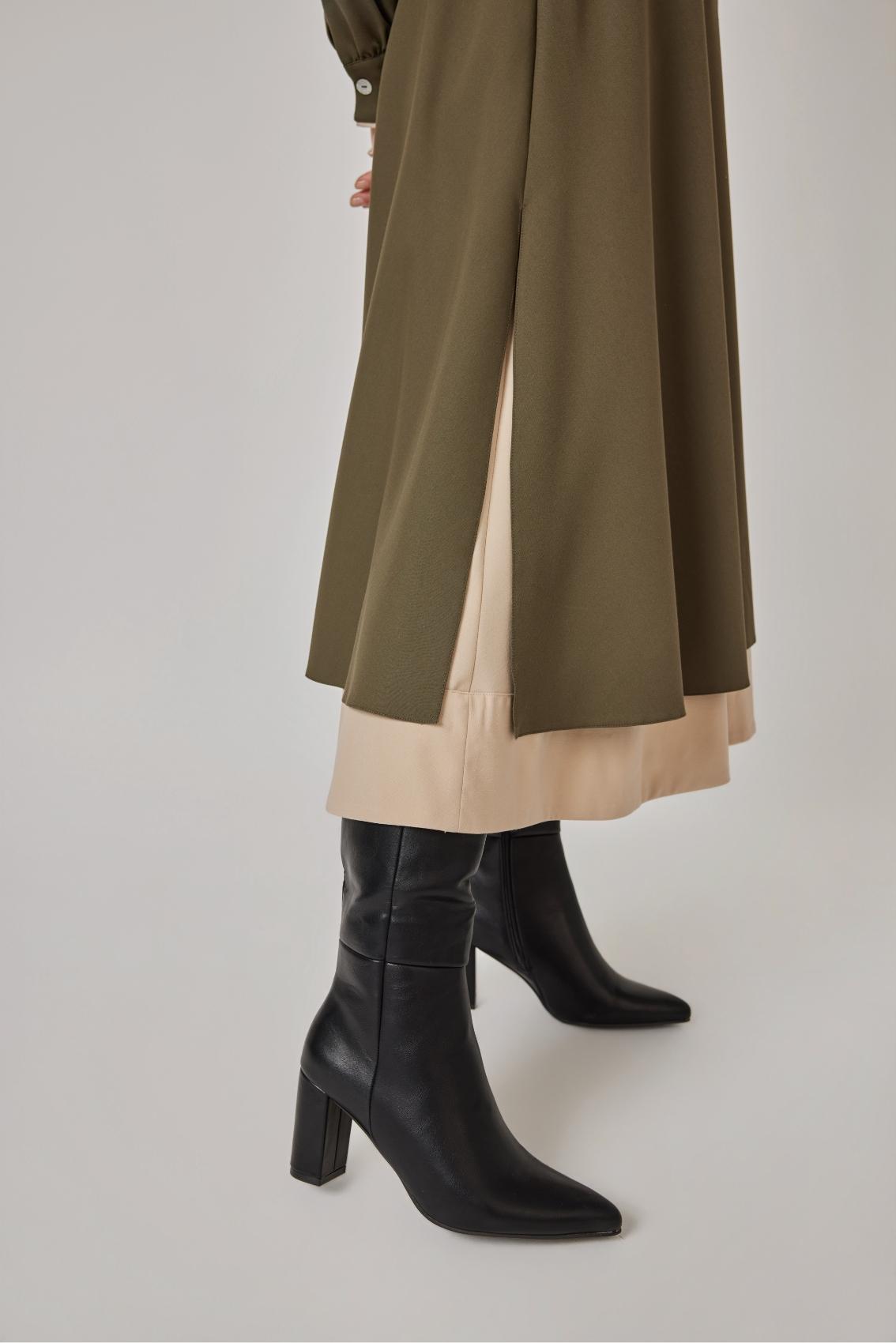 Detailansicht: Wickeloberteil in Olive mit Bindegürtel-Schleife und Manschette mit Perlmuttknopf.