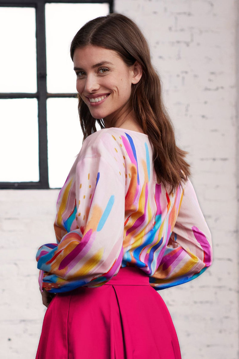 Model in Seitenansicht trägt eine Bluse mit Pinselstrich-Druck
