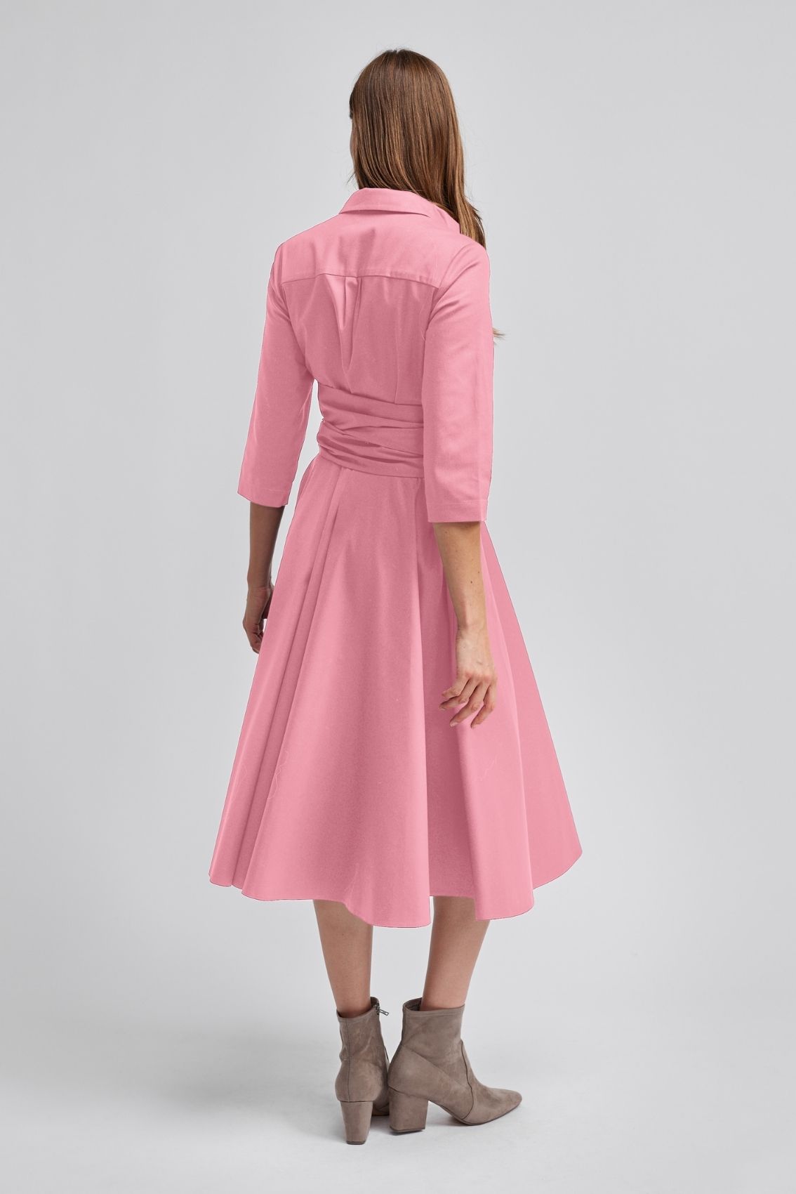 Model trägt roséfarbenes Blusenkleid in Rückenansicht mit 3/4-Ärmeln und taillierter Silhouette.
