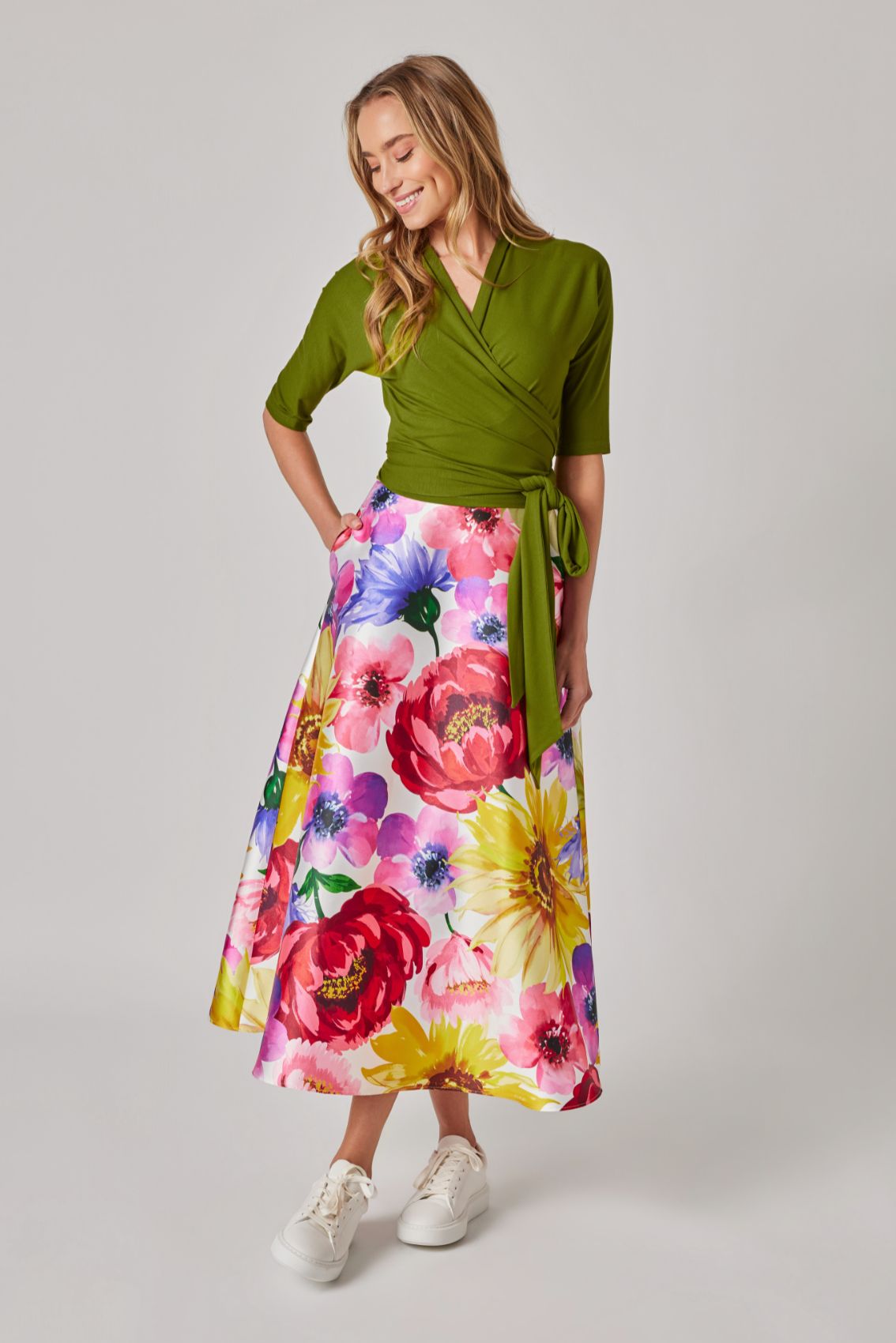 Model trägt Midirock Sommerblumen mit Seitentasche, floraler Print auf hellem Grund.