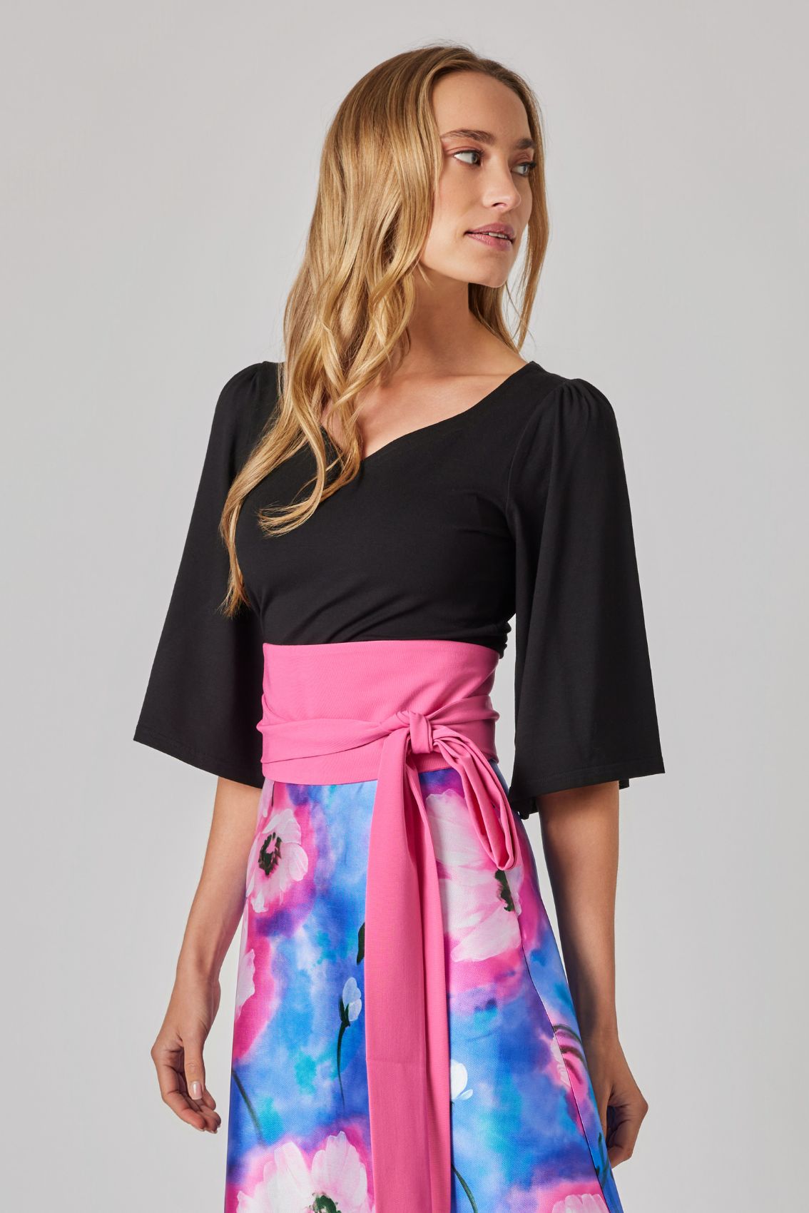 Model trägt schwarzes Viskose-Shirt mit Herz-Ausschnitt, 3/4-Ärmel mit Schwung.