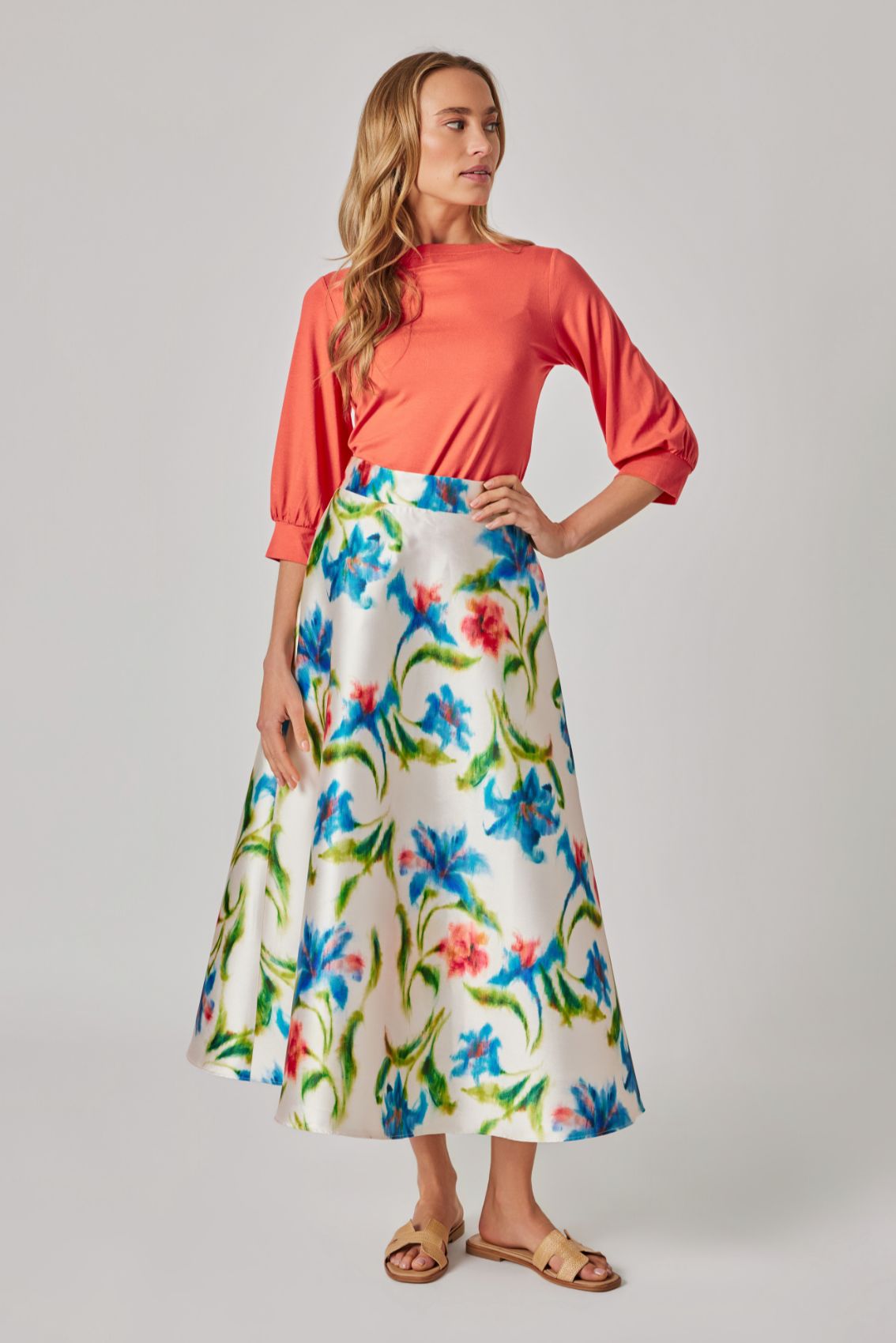 Model trägt Midirock „Kornblumenprint“ in A-Linie mit schwingendem Fall.