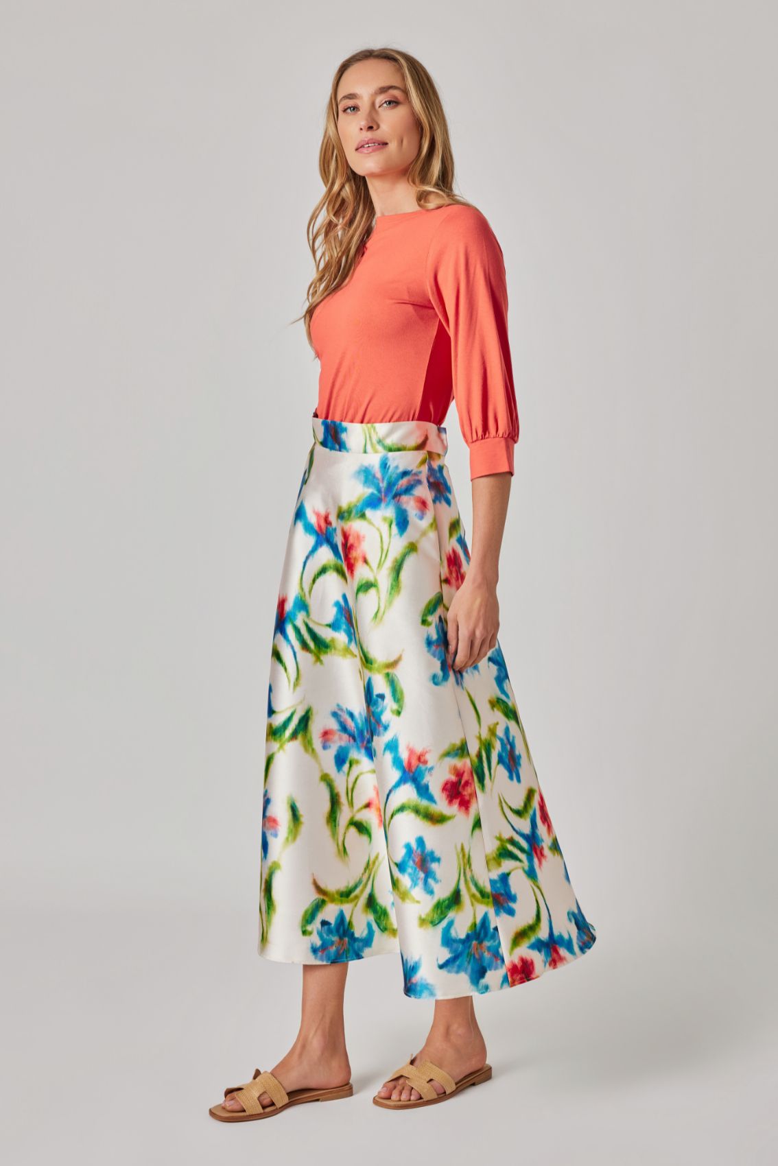 Model trägt Midirock „Kornblumenprint“, Seitenansicht mit klarer Taille und ausgestellter Silhouette.