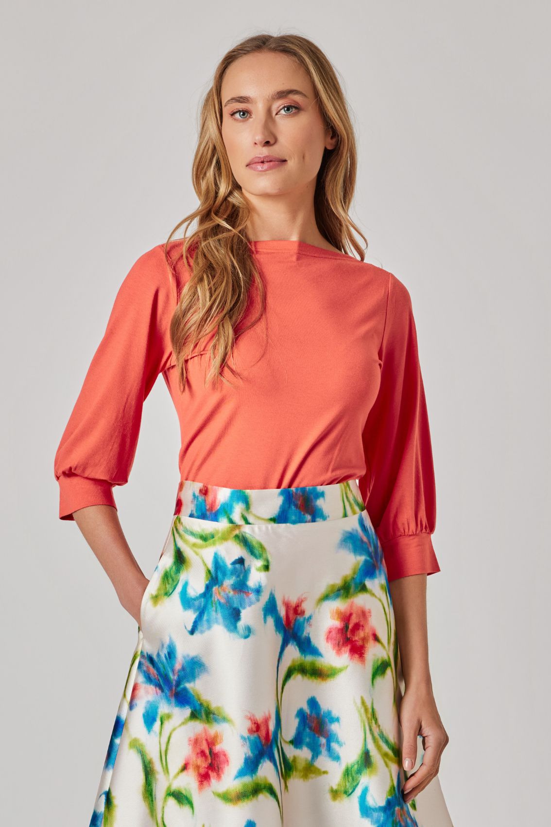 Model trägt orangefarbenes Shirt mit Manschettenärmeln, Frontansicht, U-Boot-Ausschnitt und normaler Fit.