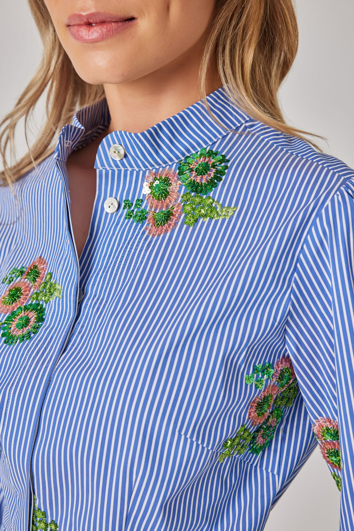 Detailansicht von Stehkragen und durchgehender verdeckter Knopfleiste der Bluse.