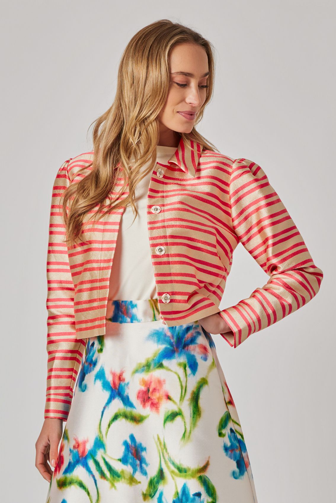 Model trägt gold-orange Streifen-Kurzjacke mit leichtem Schimmer und cropped Länge.