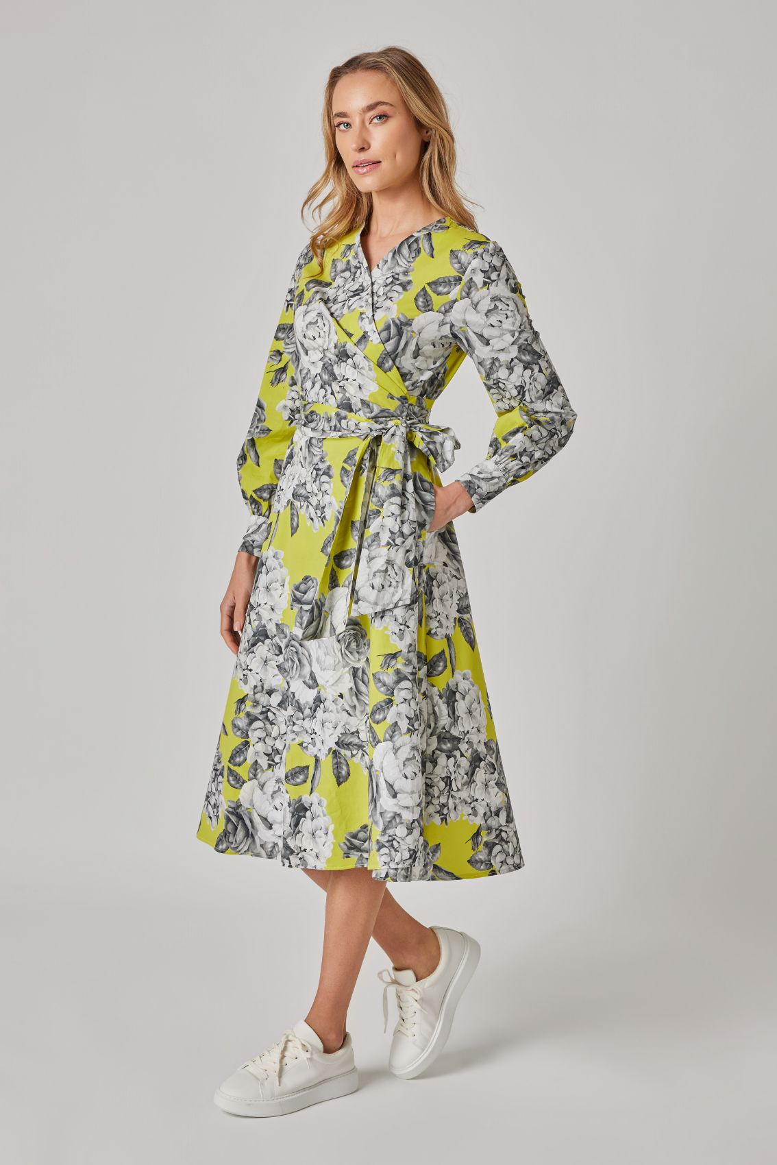 Model trägt Wickelkleid Rosenblüte, Seitenansicht mit taillenbetonter Wicklung und Midi-Länge.