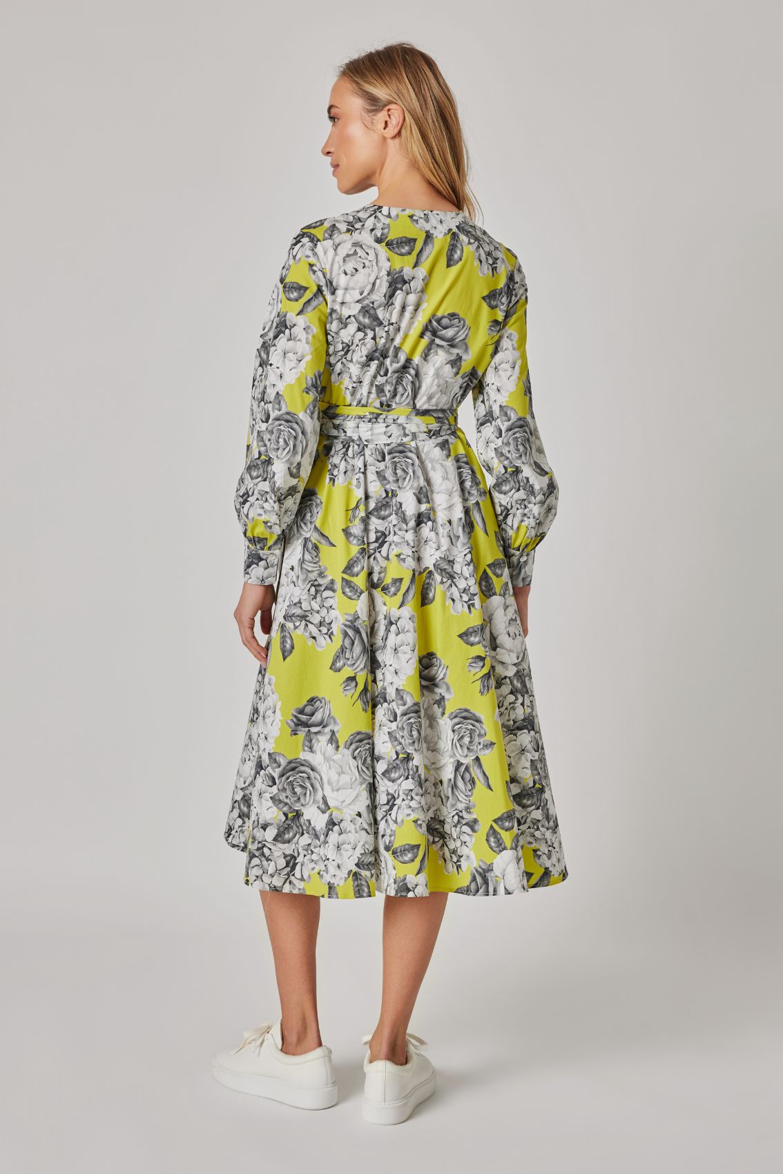 Model trägt Wickelkleid Rosenblüte, Rückansicht mit Rosenprint und locker fallenden langen Ärmeln.