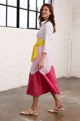 Model in  Seitenansicht in einem Blusenkleid mit Colorblock-Farben Gelb, Rosa und Pink 