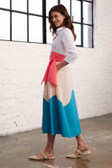 Model in Seitenansicht in einem Blusenkleid mit Colorblock-Farben Rosa, Apricot und Blau