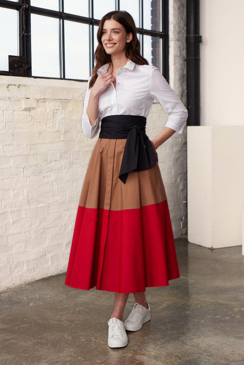 Modell in Vorderansicht trägt ein  Colorblock Blusenkleid in den Farben Karamel und Rot