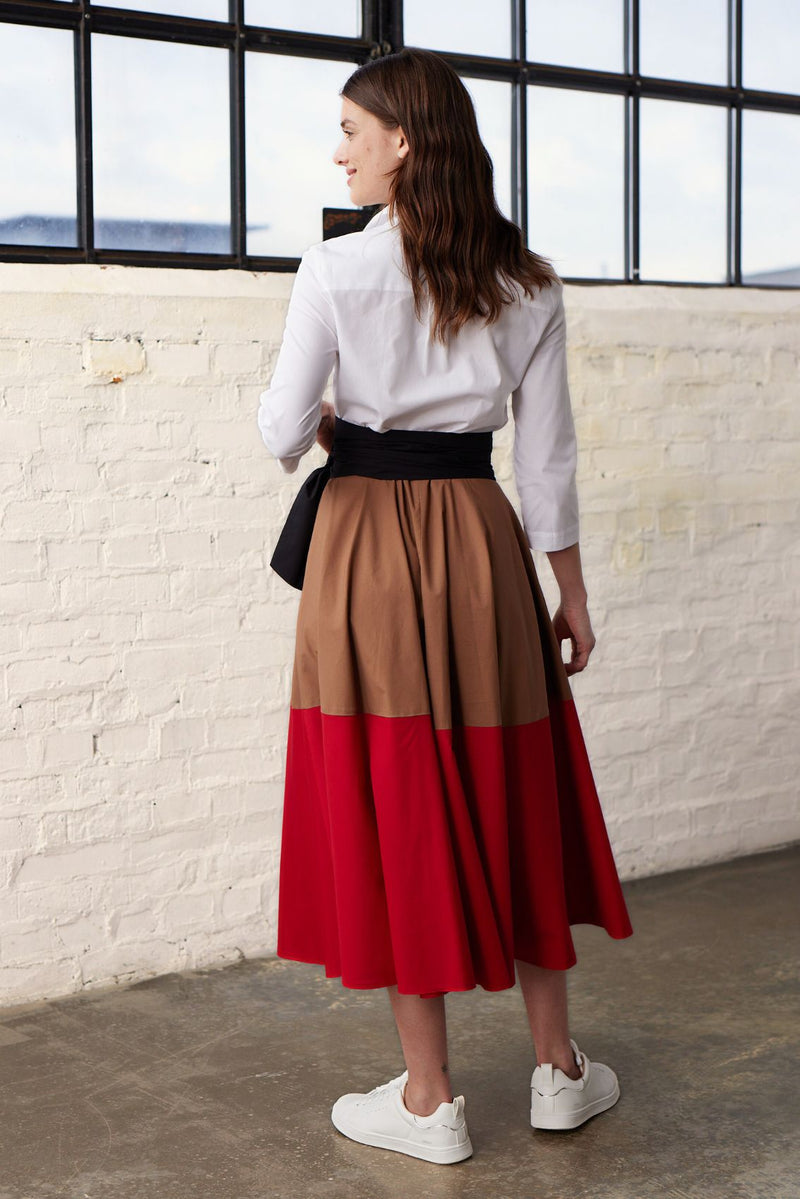 Modell in Rückansicht trägt ein  Colorblock Blusenkleid in den Farben Karamel und Rot