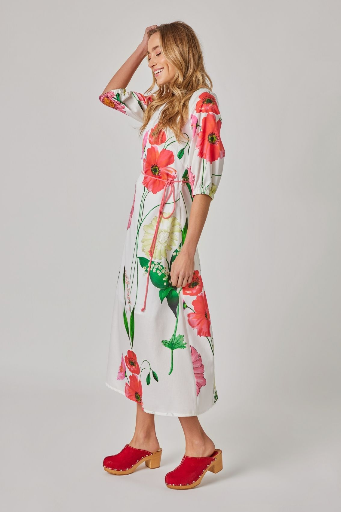 Model trägt florales Midikleid mit 3/4-Ärmeln und leicht ausgestelltem Rock, Seitenansicht.