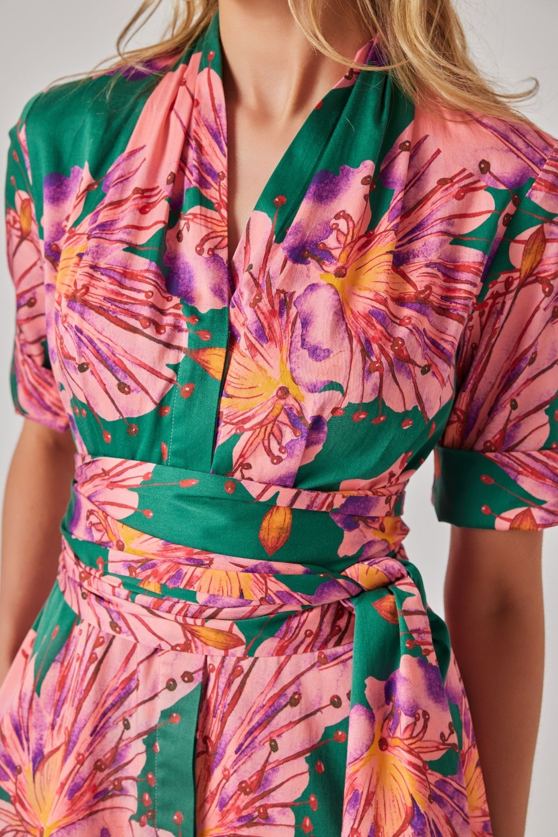 Model trägt florales Blusenkleid mit abnehmbarem Gürtel, Detailansicht mit tailliertem Sitz.