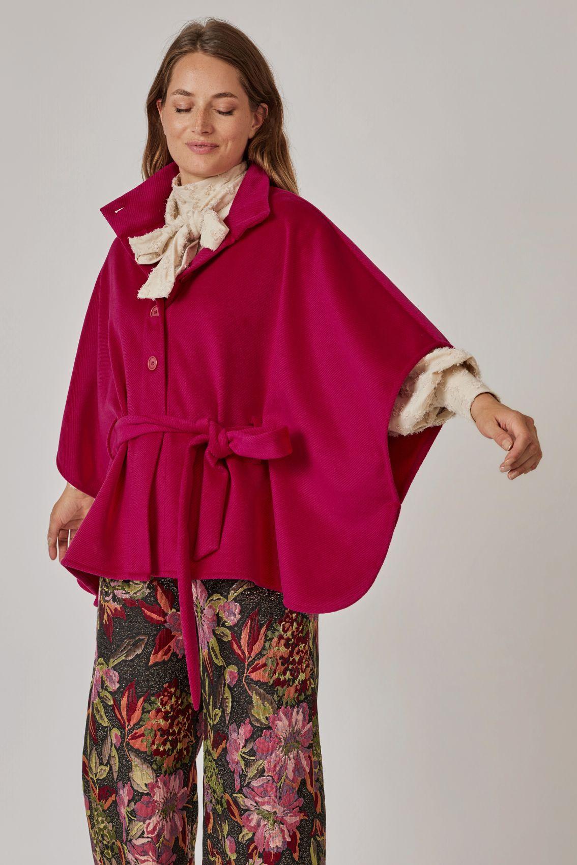 Model trägt Cape Magenta, Seitenansicht mit weitem Ärmelschnitt. 