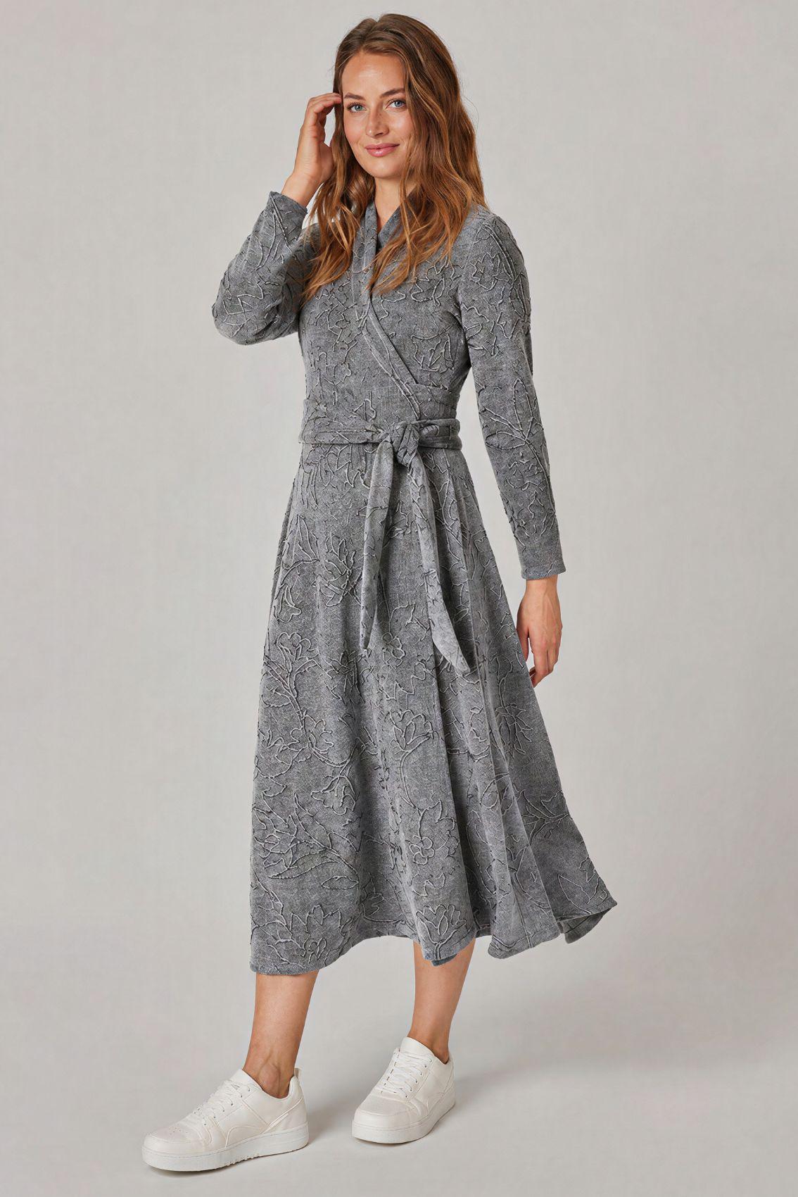 Model trägt graues Strickkleid mit Blumenstickerei, Wickel und Bindegürtel, Frontansicht.