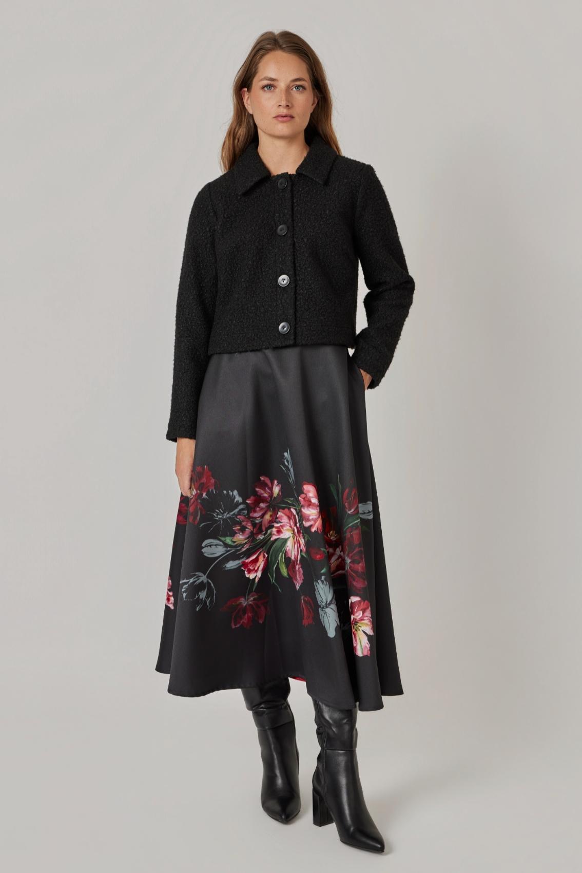 Model trägt Rock mit Blumenbouquet-Print und Seitentaschen, kombiniert mit Bouclé-Jacke, Frontansicht. 