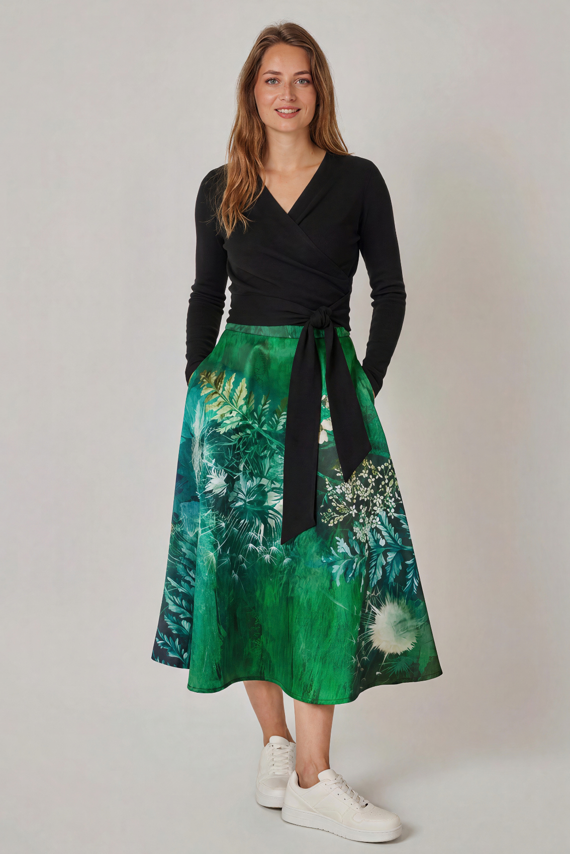 Model trägt Rock mit Wildblumen-Print und Seitentaschen, kombiniert mit Jacke, Frontansicht. 
