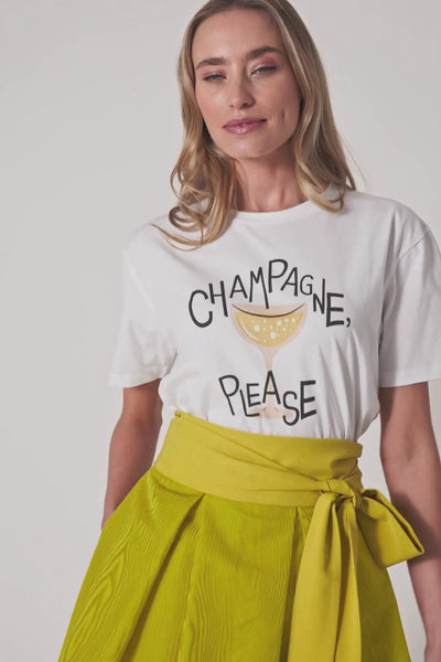 Model trägt weißes T-Shirt mit „Champagne Please“-Print in Bewegung, kombiniert mit gelbem Rock, verschiedene Perspektiven.
