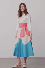 Model dreht sich in einem Blusenkleid mit Colorblock-Farben Rosa, Apricot und Blau