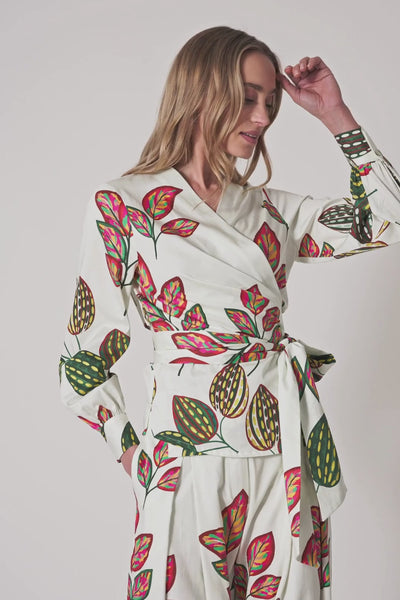 Model trägt helle High-Waist Hose mit weitem Bein und buntem Blätter-Print