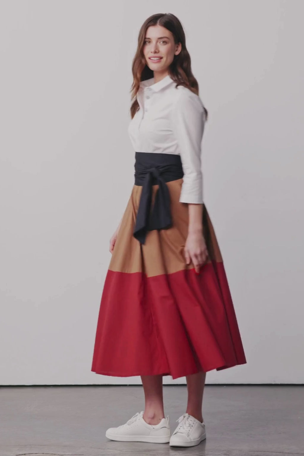 Modell dreht sich und trägt ein  Colorblock Blusenkleid in den Farben Karamel und Rot