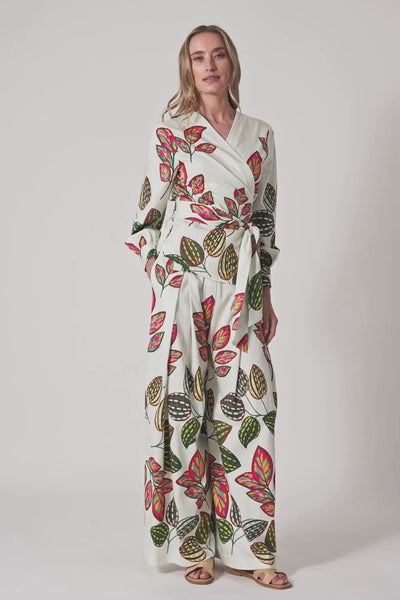 Model trägt weiße, weite Hose mit Blattprint und hohem Wickelbund mit Bindegürtel.