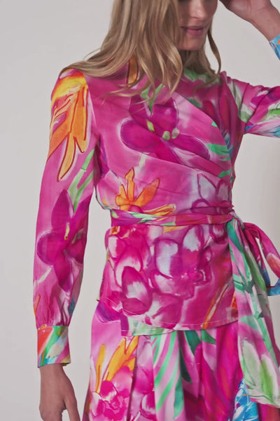 Model trägt pinkes Wickeloberteil mit Bindegürtel und Aquarell-Blumenprint