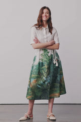 Modell dreht sich und trägt einen Blusenkleid mit Palmen-Print