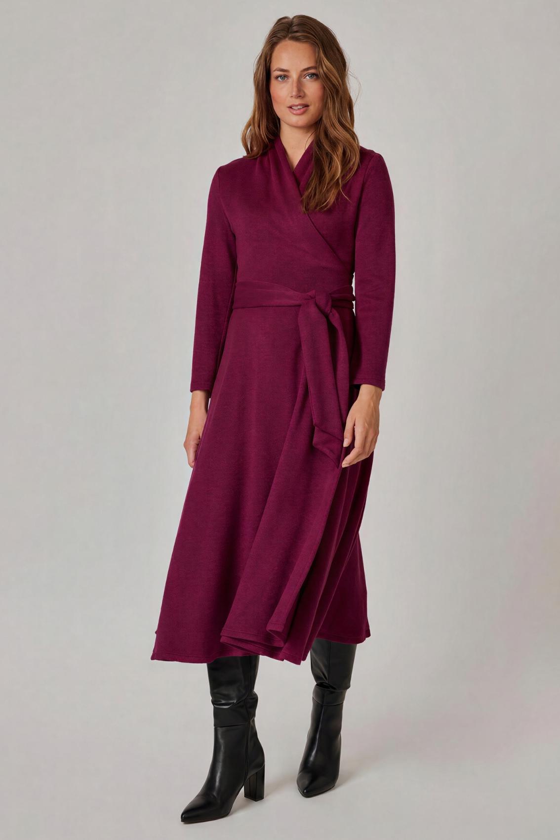 Model trägt Strick Wickelkleid in Beere mit gebundenem Bindegürtel, Frontansicht.