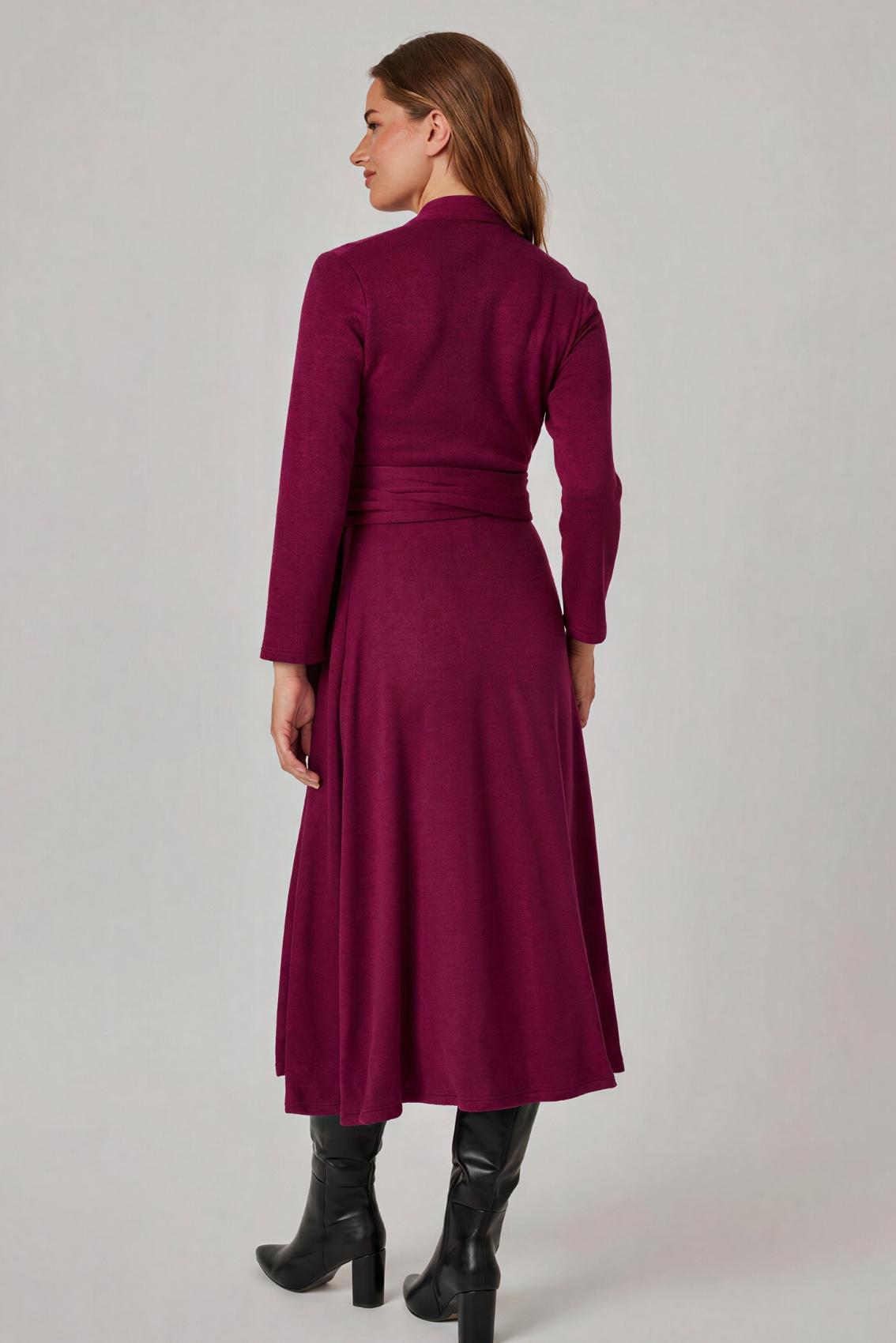 Model trägt beerefarbenes Wickelkleid, Rückenansicht mit zur Schleife gebundenem Bindegürtel.