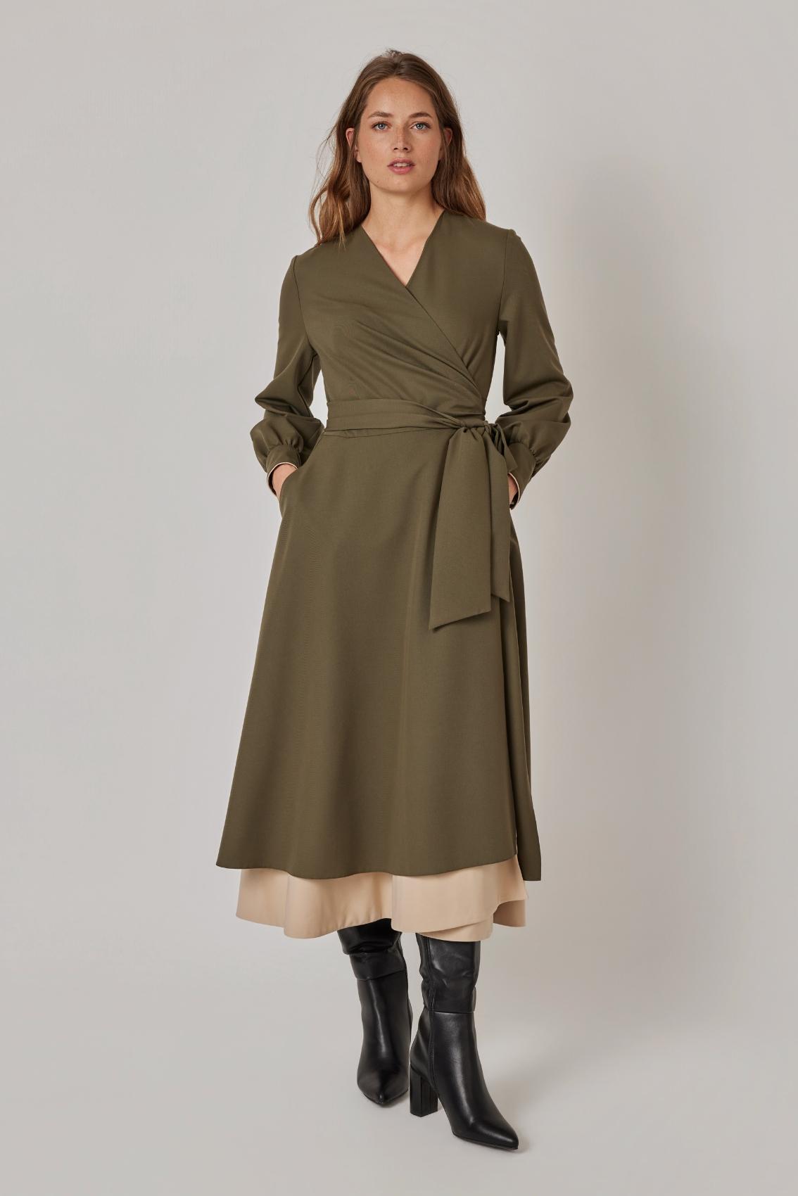 Model trägt Wickelkleid Olive-Sand mit Bindegürtel und Seitentaschen, Frontansicht.